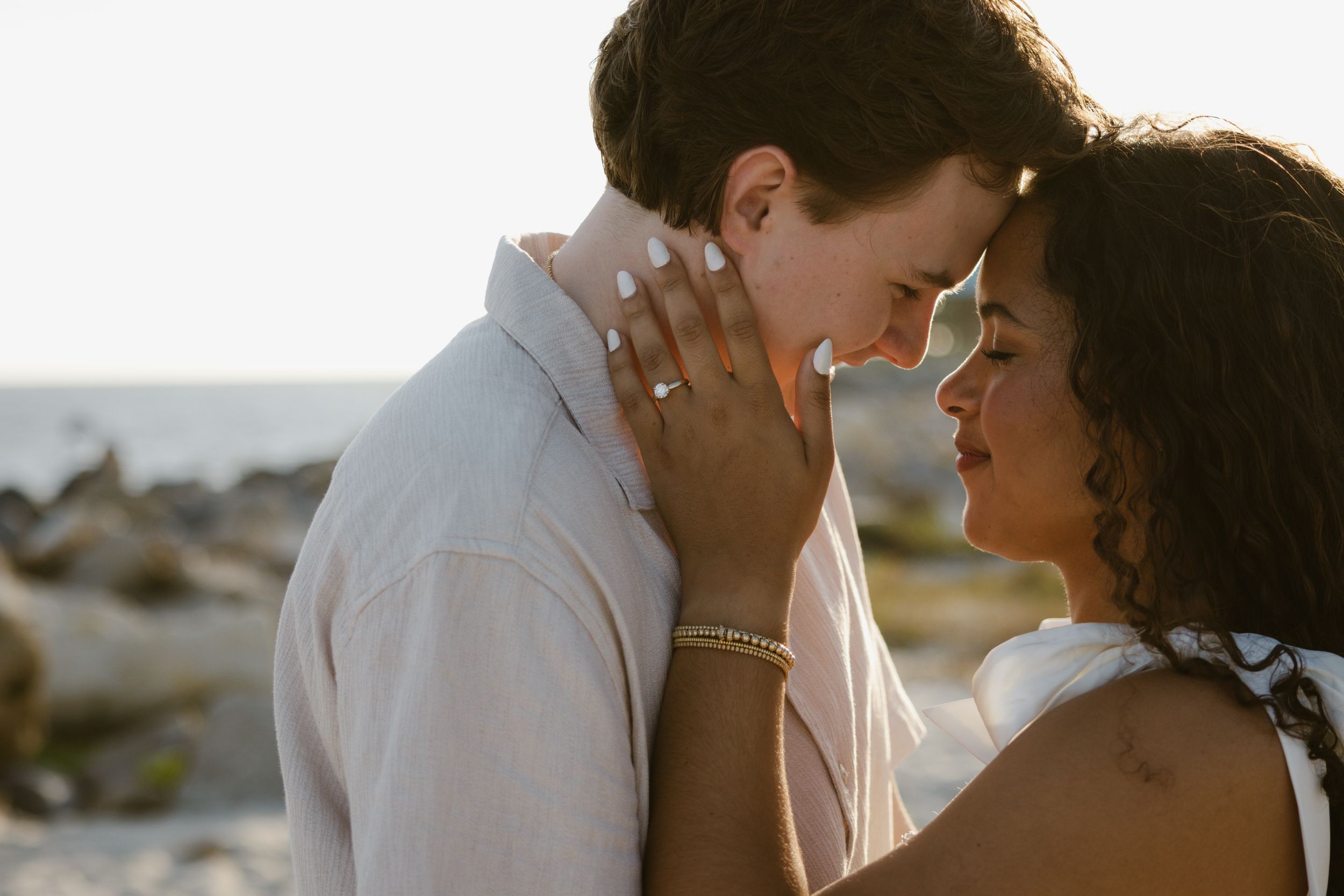 Evening engagement photos on a rocky beach in Florida.