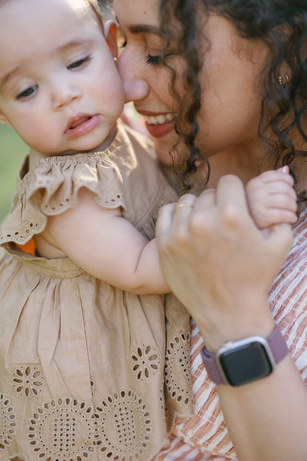 Intimate close-up of parent and baby sharing a tender embrace while wearing complementary outfits.