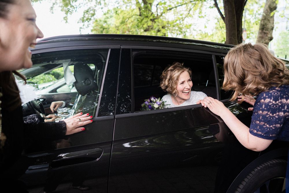 Candid interaction through a car window during a wedding day.
