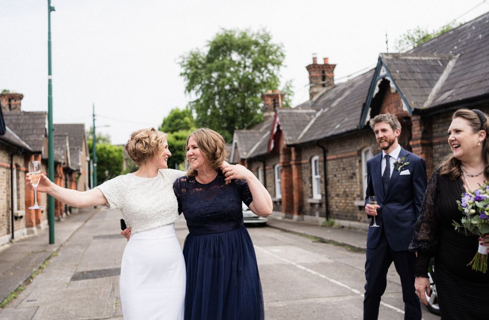 Wedding celebration on a charming residential street with couples laughing together.