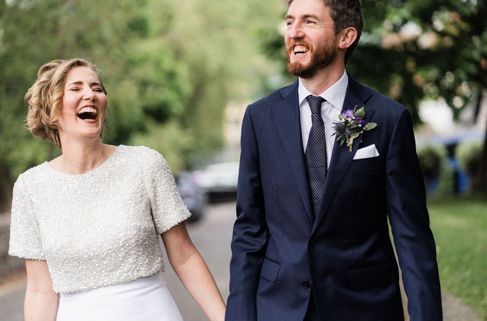 A candid moment of laughter between newlyweds in their wedding attire.