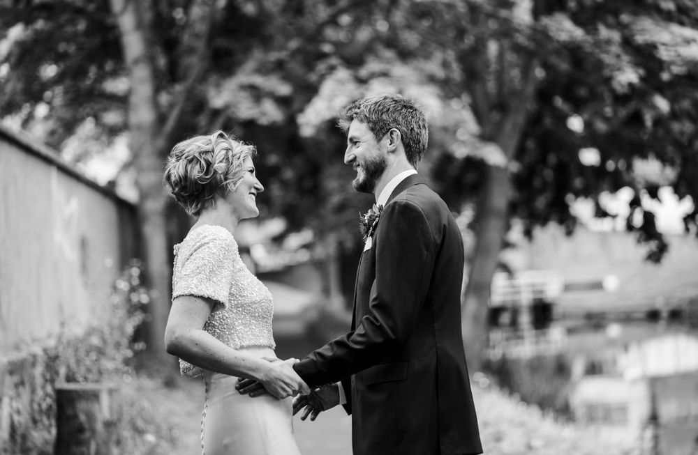A black and white wedding portrait showing a tender moment between newlyweds.
