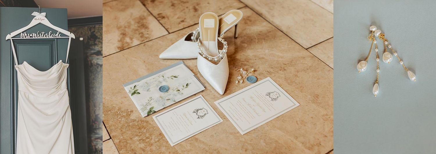 Wedding details flat lay featuring dress on hanger, invitation suite and delicate accessories.
