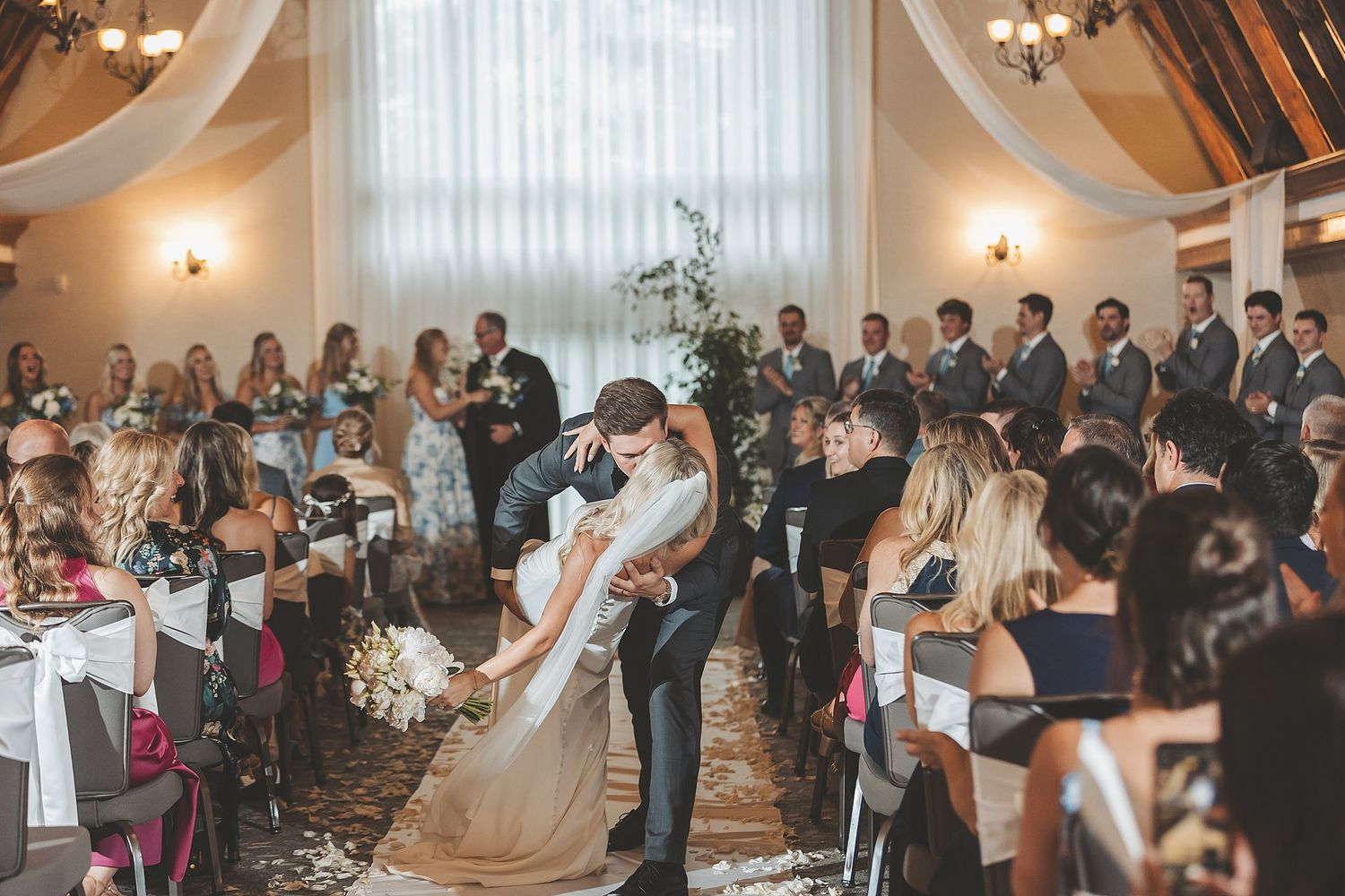 Wedding ceremony moment captured from above showing guests seated in rows.