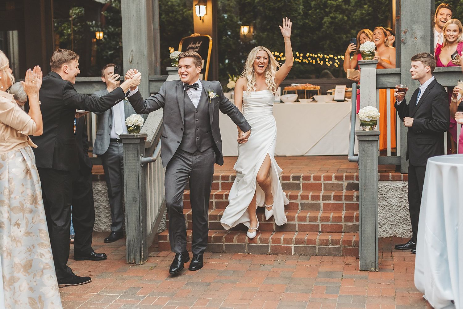 Celebratory grand entrance of couple at outdoor wedding reception.