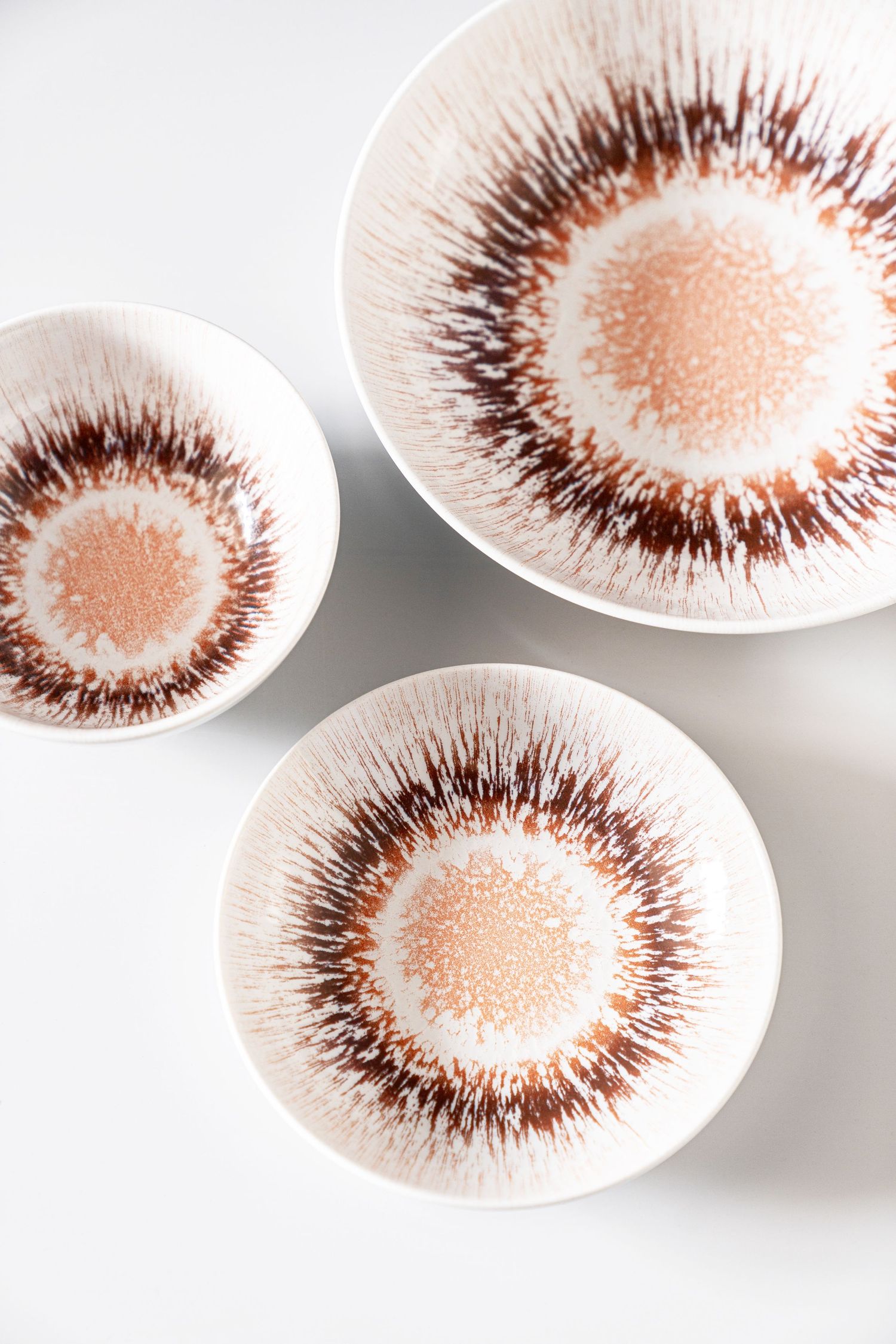 Porcelain collection Spheres with digital print in various earthy tones and radial patterns.
