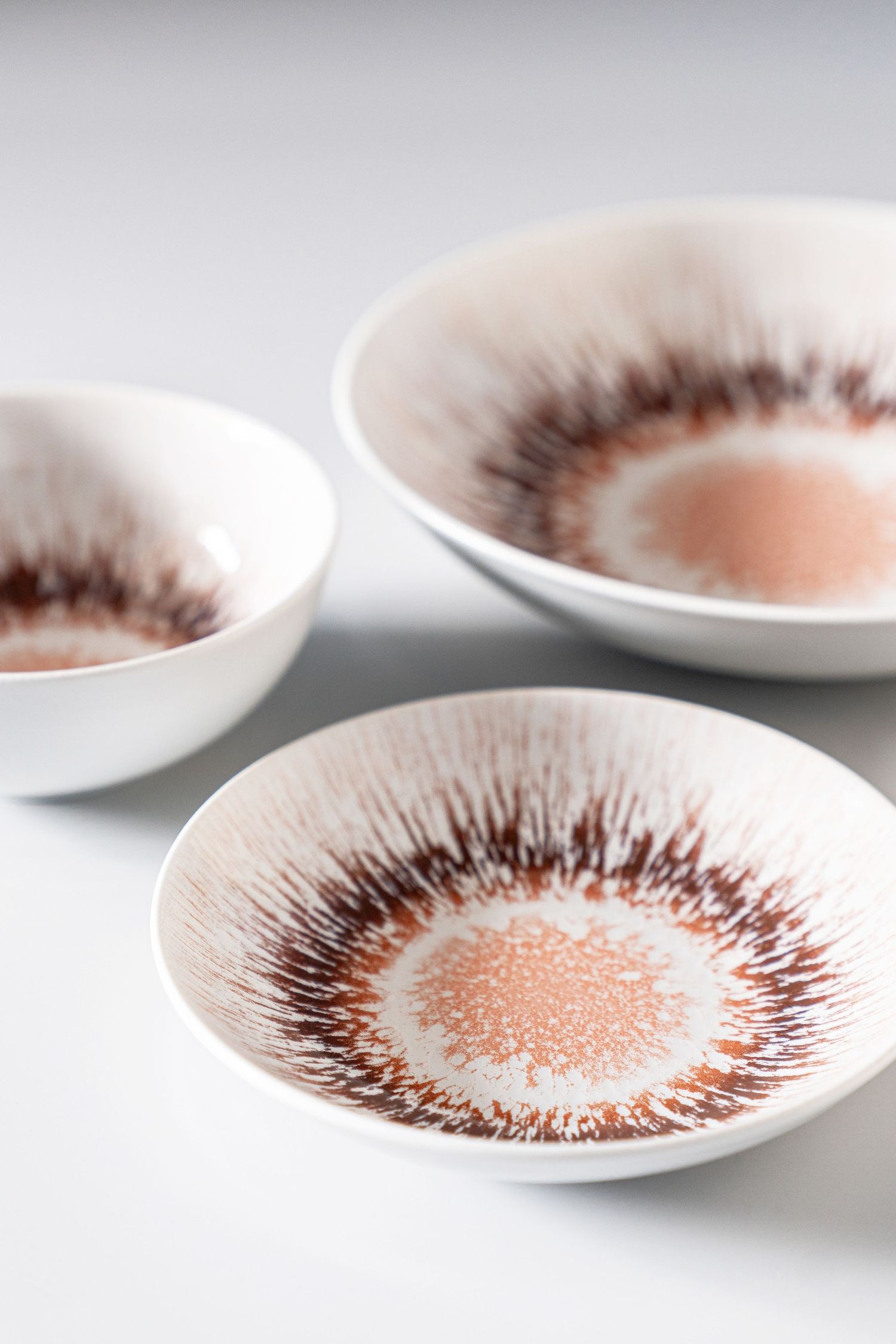 Porcelain collection Spheres with digital print in various earthy tones and radial patterns.