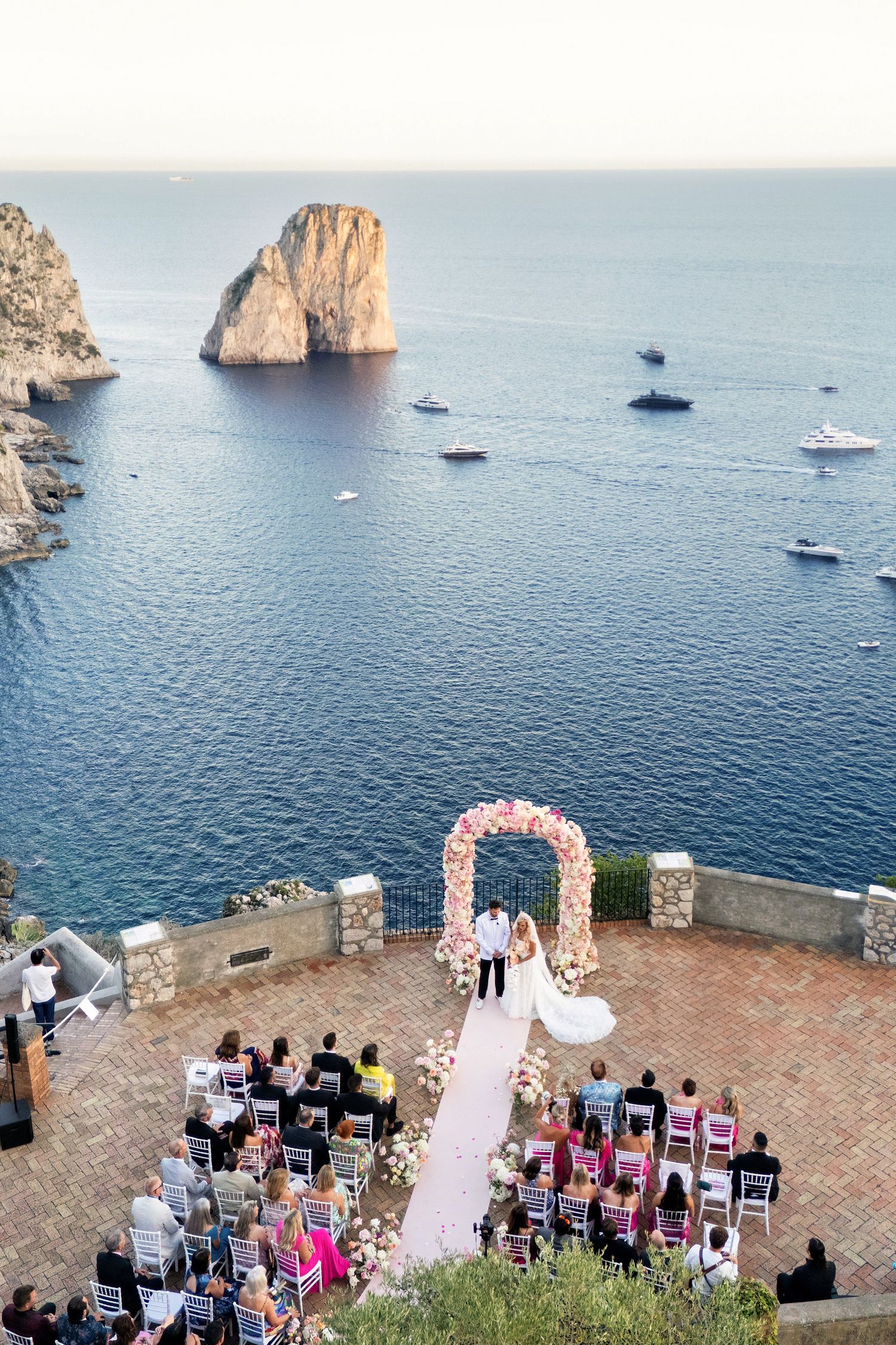 Scenic wedding ceremony overlooking a beautiful mountain coastline with clear blue skies.