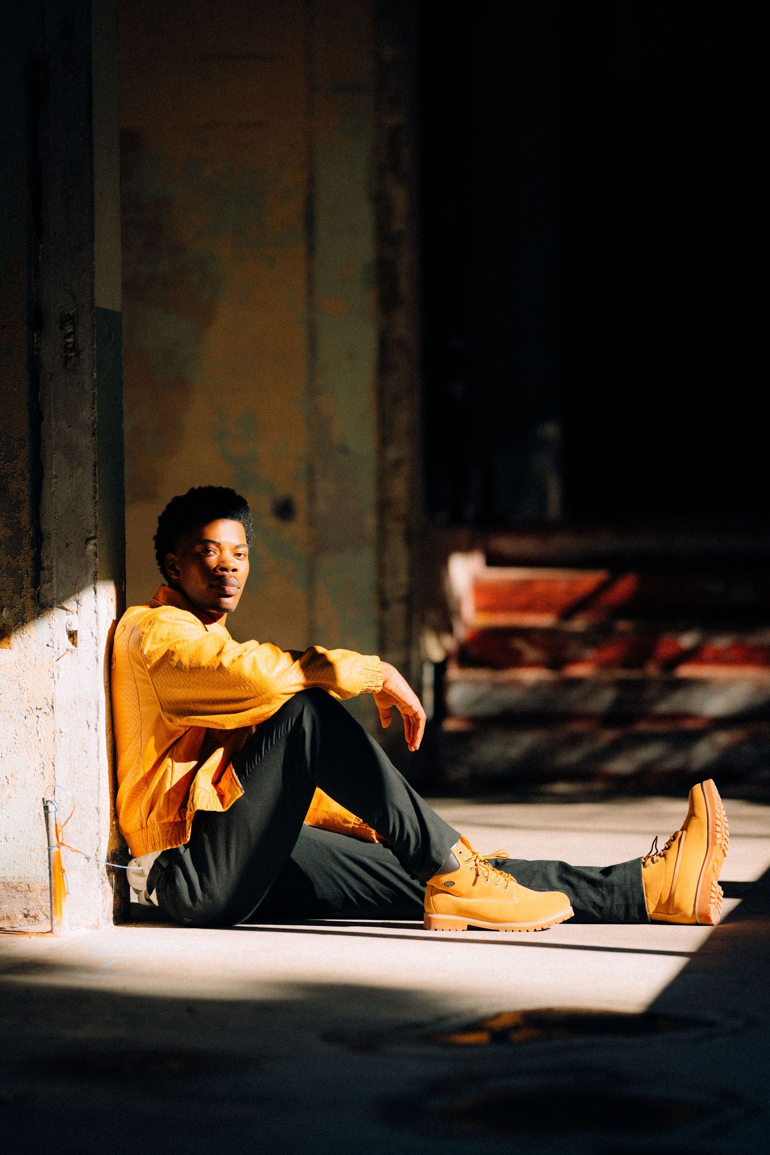 Guy sitting against pillar in sunlight