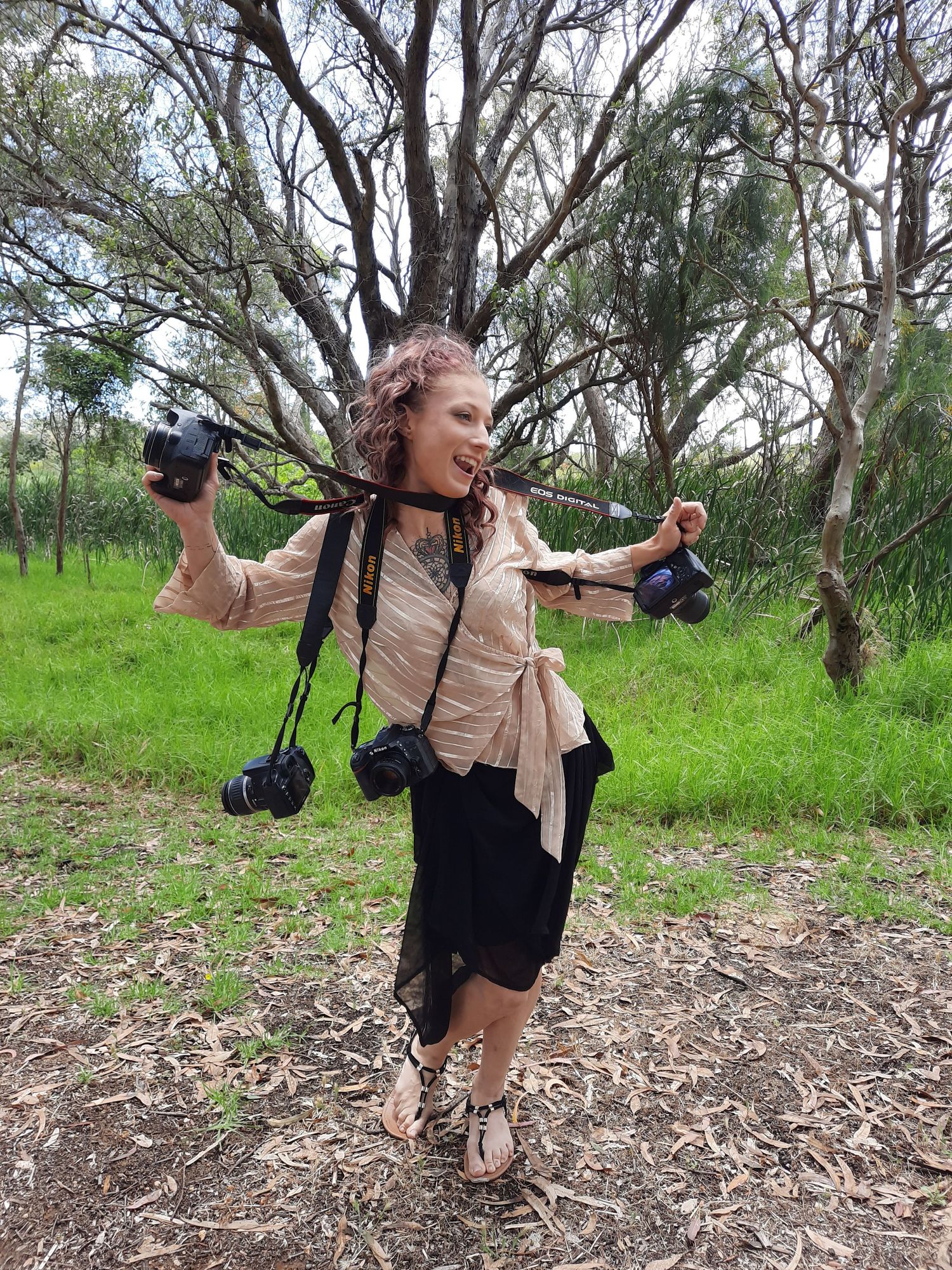 Photographer with cameras enjoying a candid moment in nature.