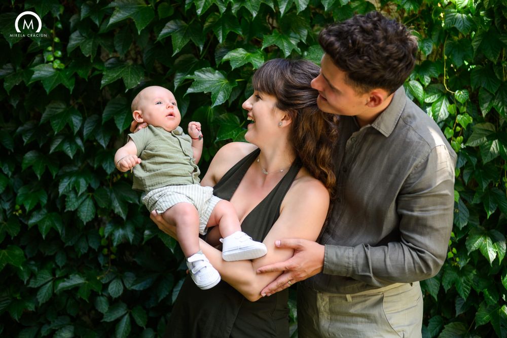 A loving family shares a joyful moment together against a lush green garden backdrop.