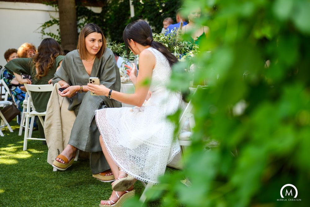 Two people in conversation on lawn chairs at garden party.
