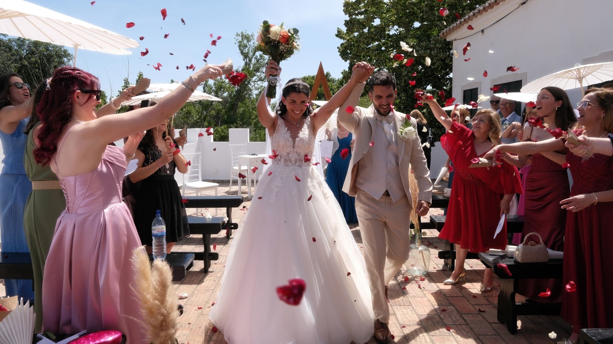 Wedding couple grand exit with guests throwing rose petals.