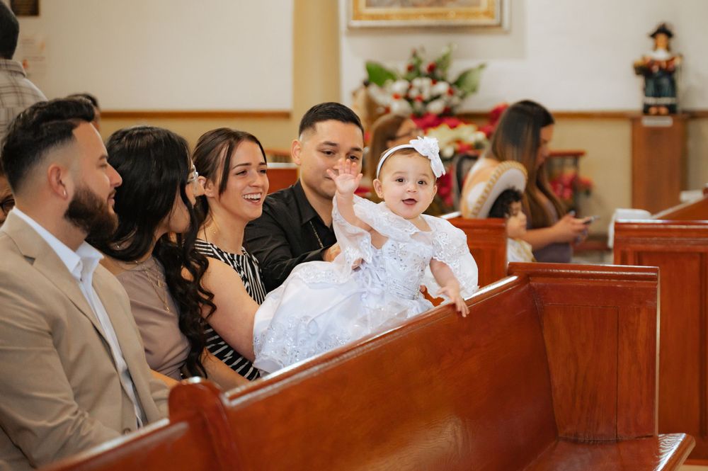 Guests seated in church pews during a religious ceremony.