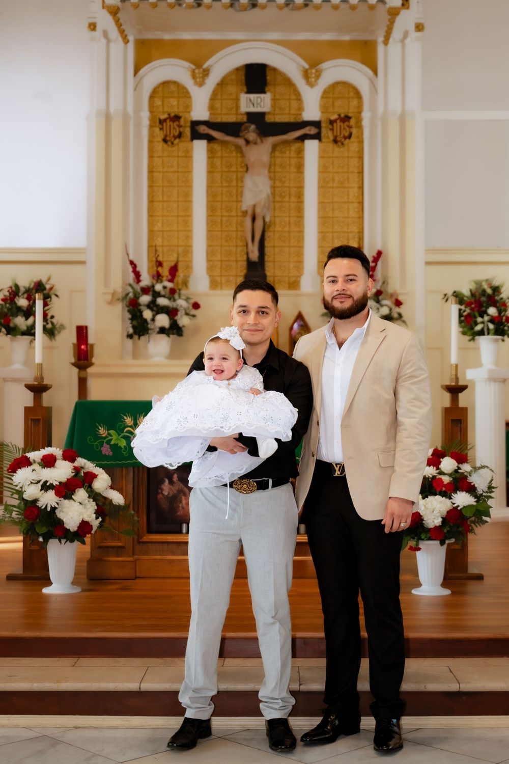 A group poses in formal attire inside a decorated church sanctuary.