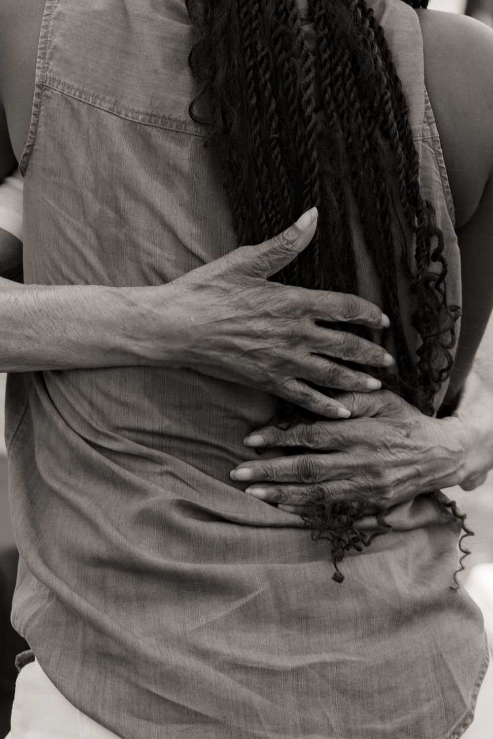 Black and white close-up sequence showing hands resting on fabric.