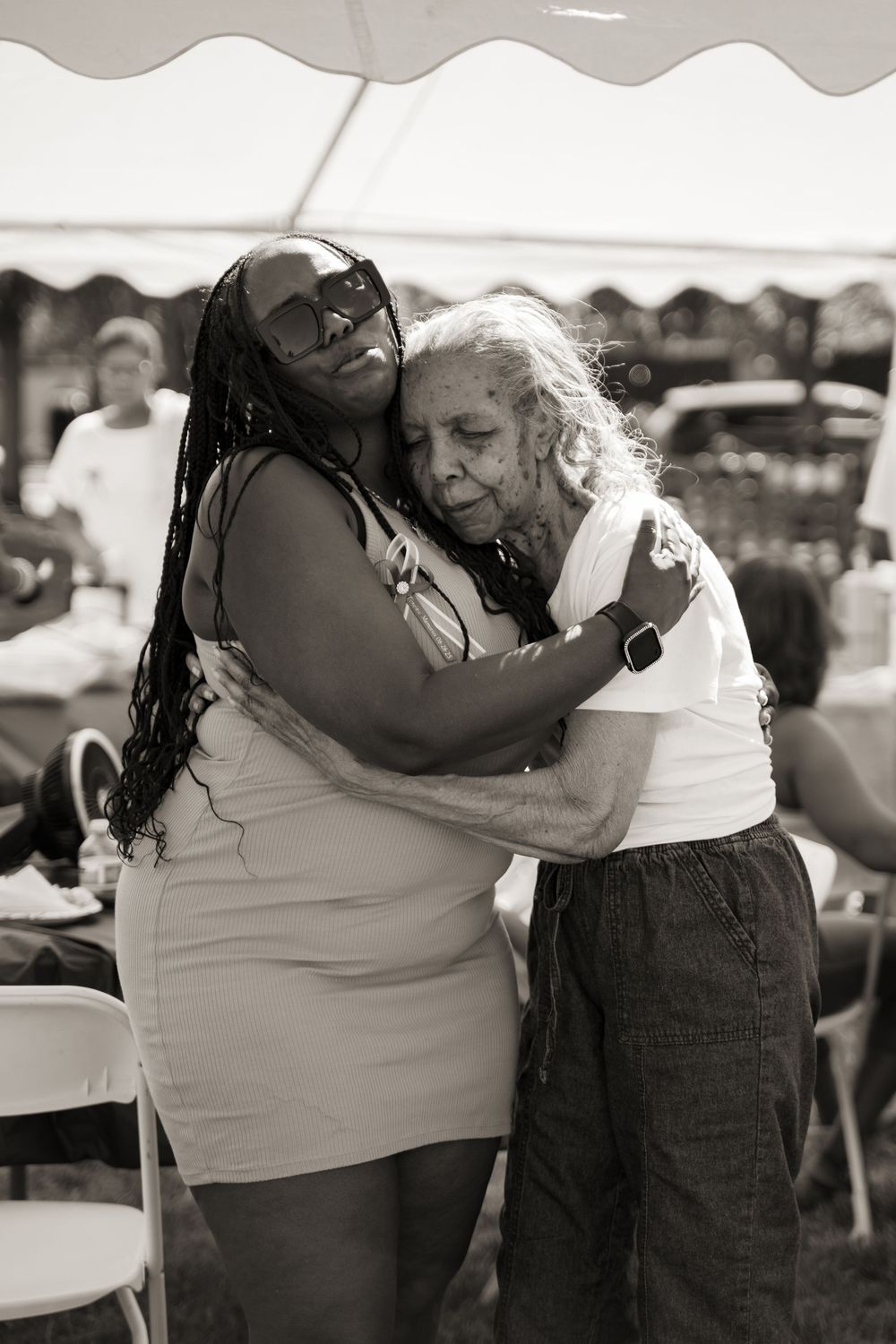 Black and white images showing people embracing at an outdoor event.