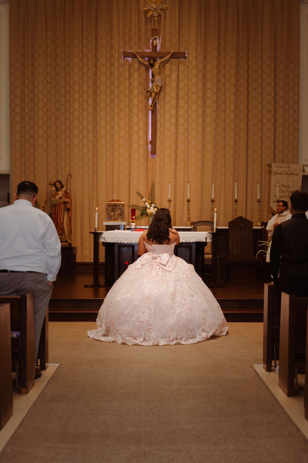 A church ceremony with wooden pews and traditional religious decor visible in the background.
