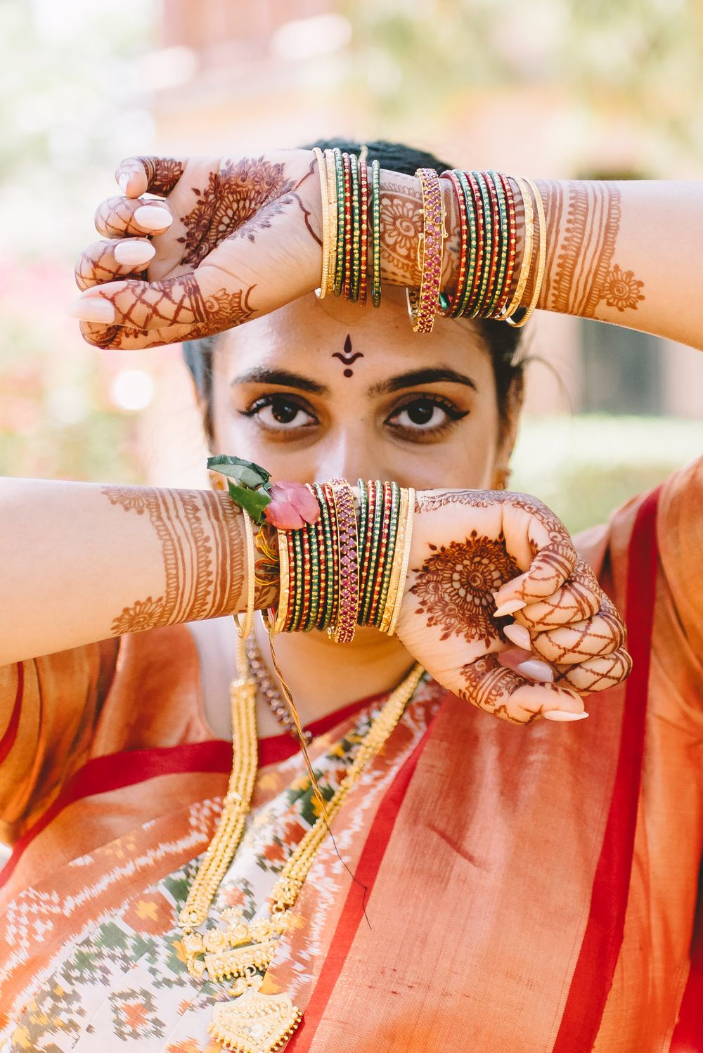 Traditional Indian bridal jewelry and henna displayed with ornate bangles and mehndi designs.