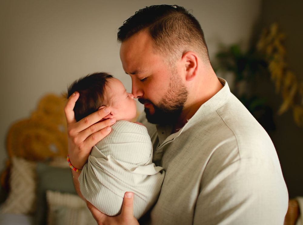 Daddy and Newborn baby boy nose to nose for newborn session in Alvin Tx