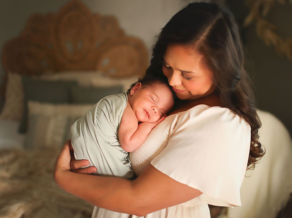 Mama snuggle newborn baby at studio