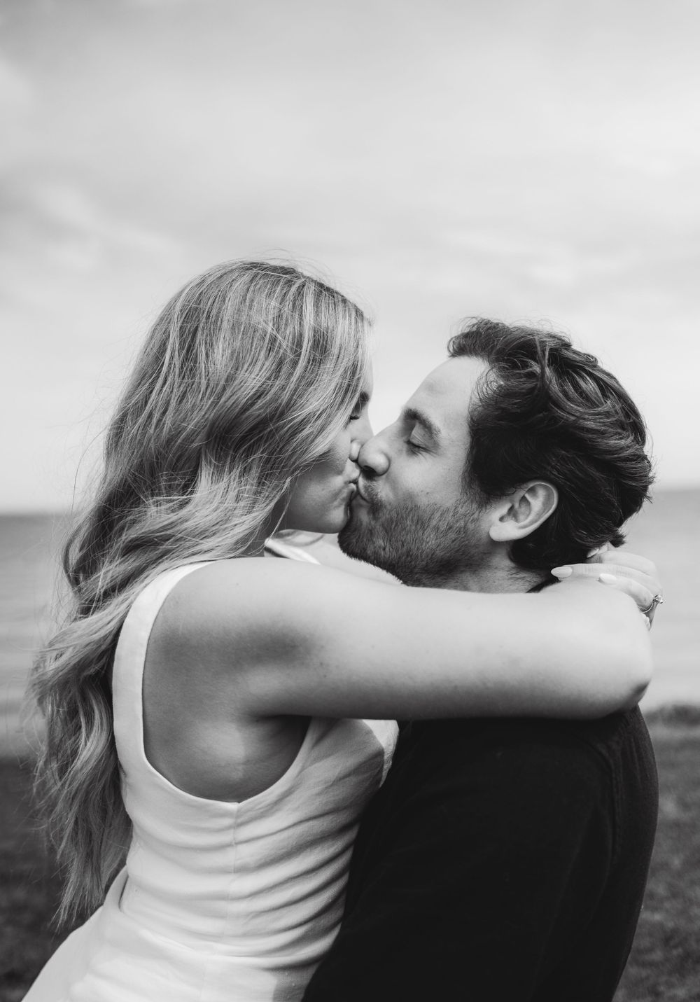 Intimate black and white portrait of romantic embrace outdoors.