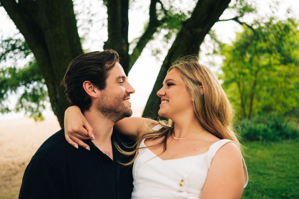 Romantic outdoor scene with couple embracing under trees.