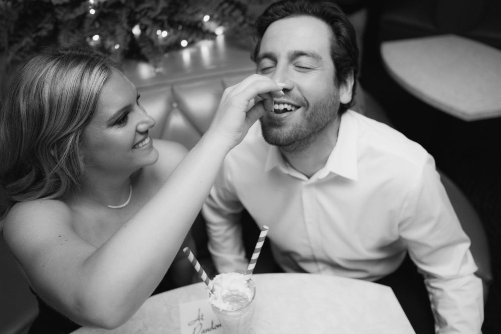 Candid black and white photo of playful moment during romantic dinner date.