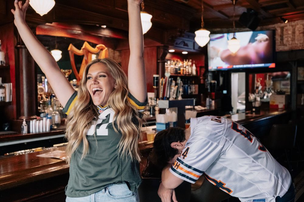 Energetic celebration at sports bar with enthusiastic reactions to game.