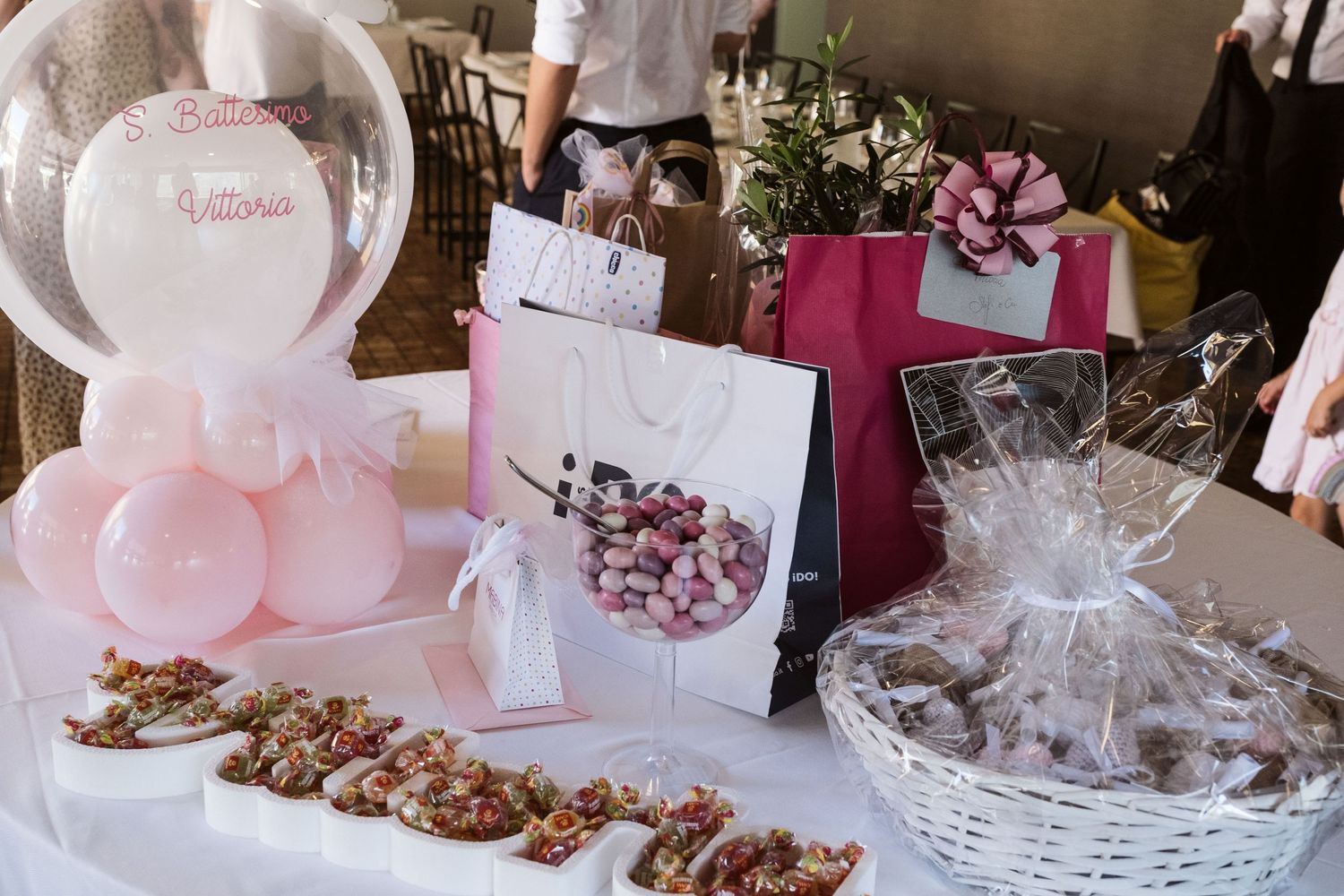 Dettaglio di un tavolo di ristorante con addobbi rosa per il festeggiamento del Battesimo di una bambina.