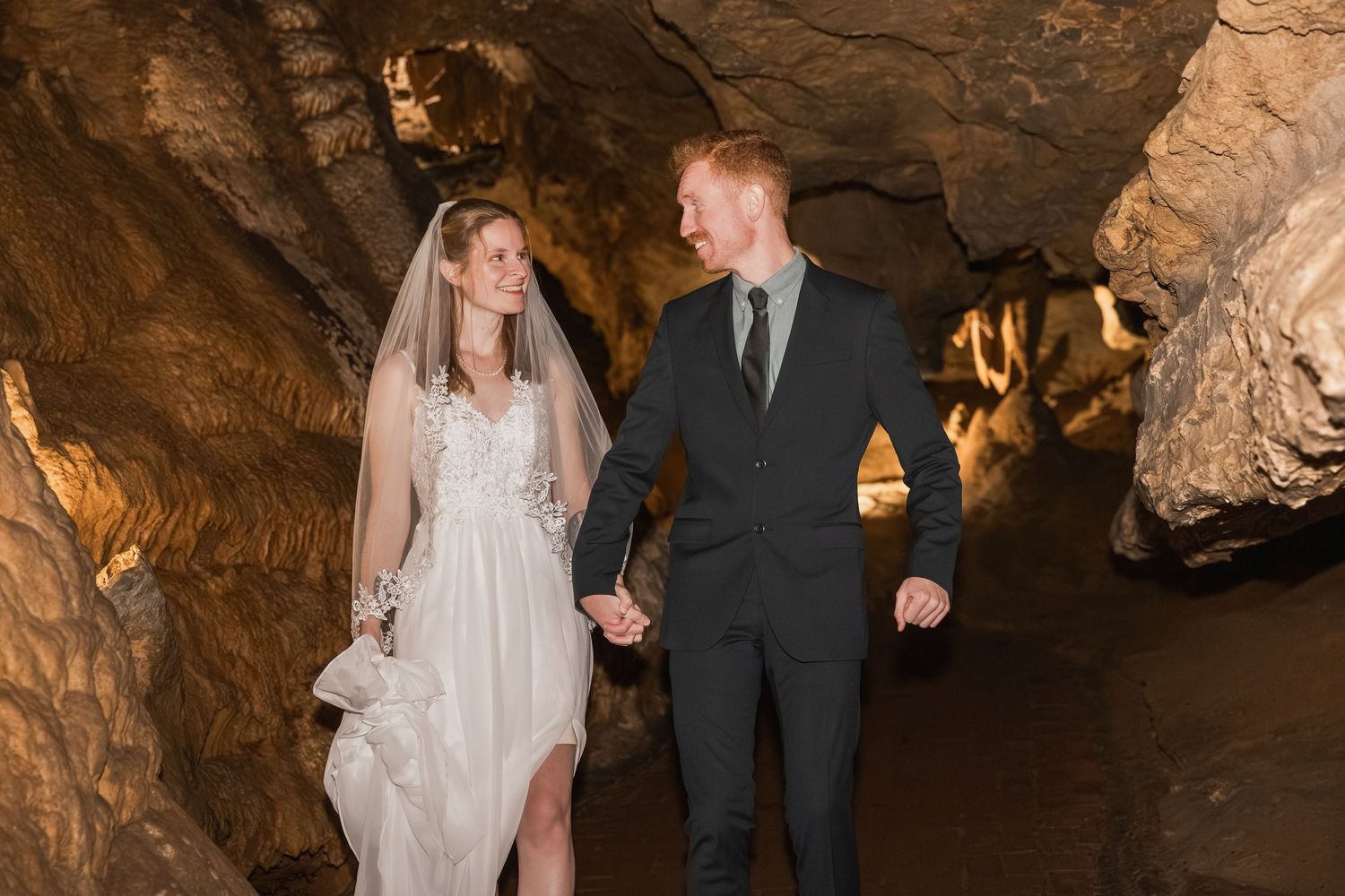 A couple walks to their wedding ceremony in the Cathedral Room in Luray Caverns, Virginia.