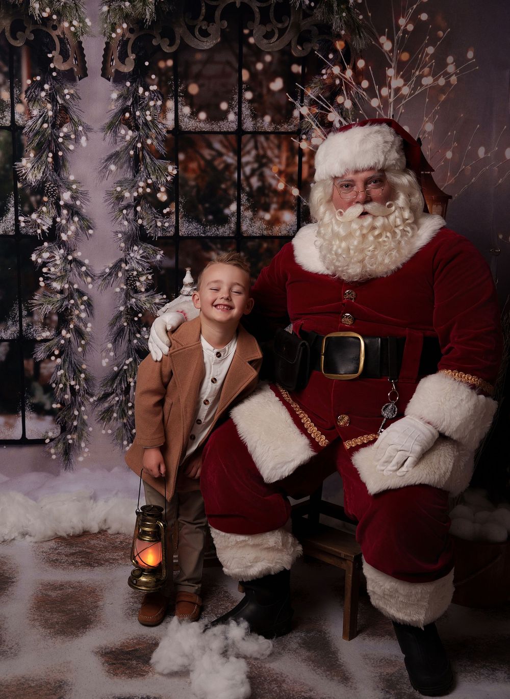 A festive holiday photo session in a snowy winter setting with lantern and Christmas decorations.