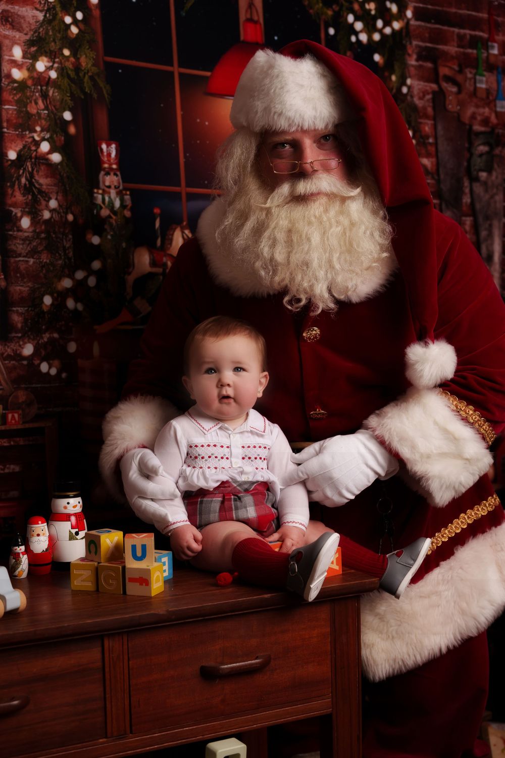 A festive Christmas setting with toy blocks and holiday decorations on a wooden table.