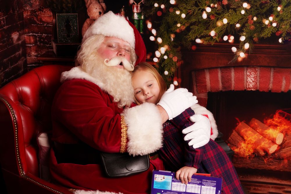 A heartwarming Christmas scene with presents and twinkling lights around a red leather chair.