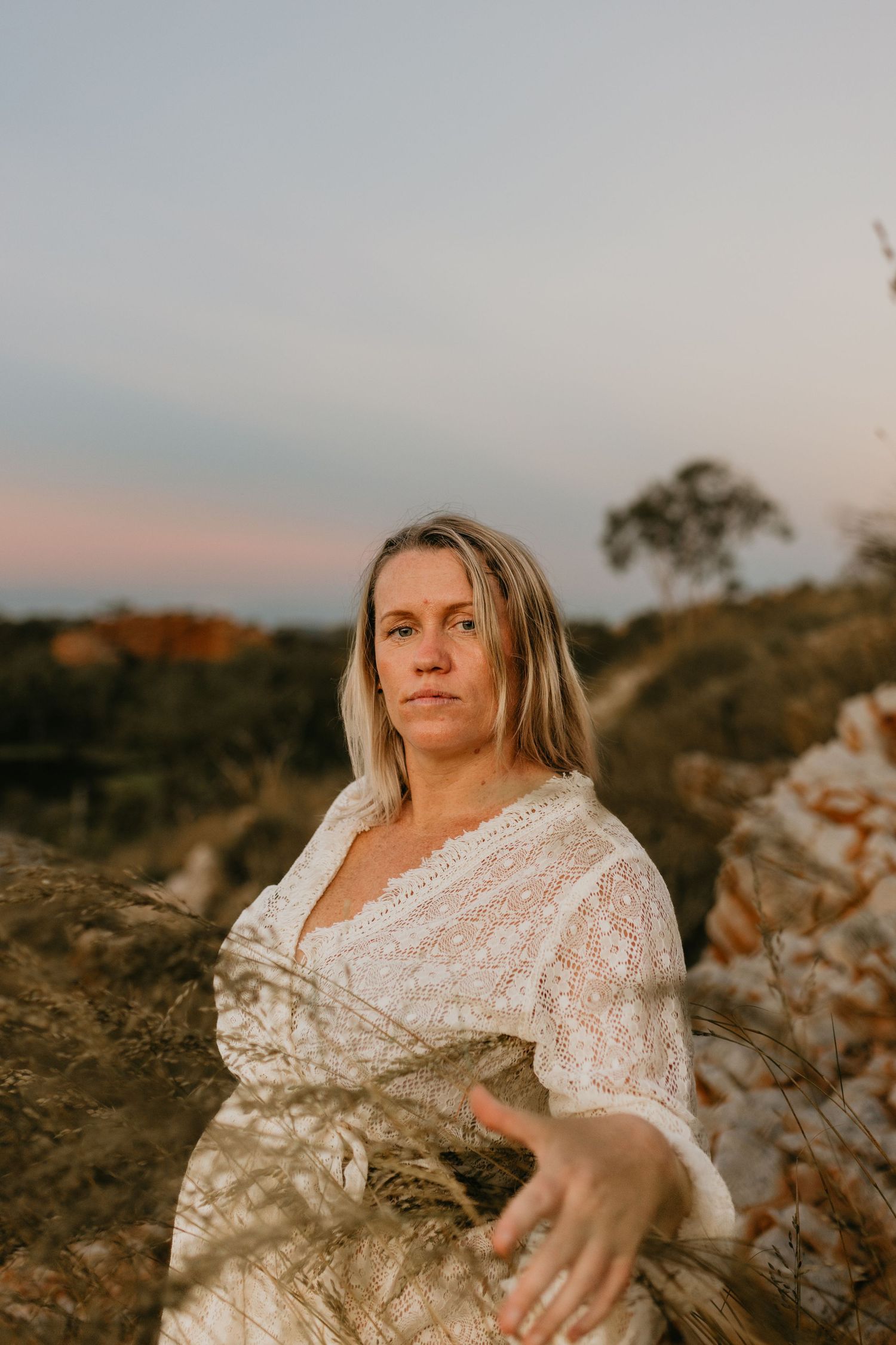 Woman looks into camera lens surrounded by foliage