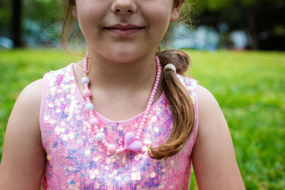 Close-up of a sparkly pink sequined tank top in an outdoor setting.