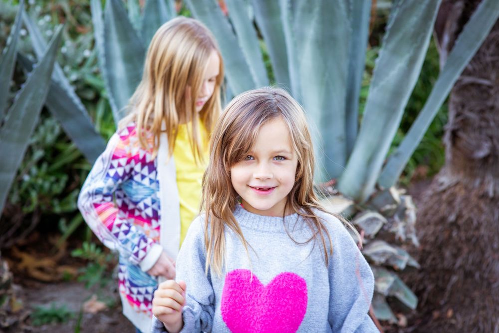 Two people posing together near agave plants in a garden setting.
