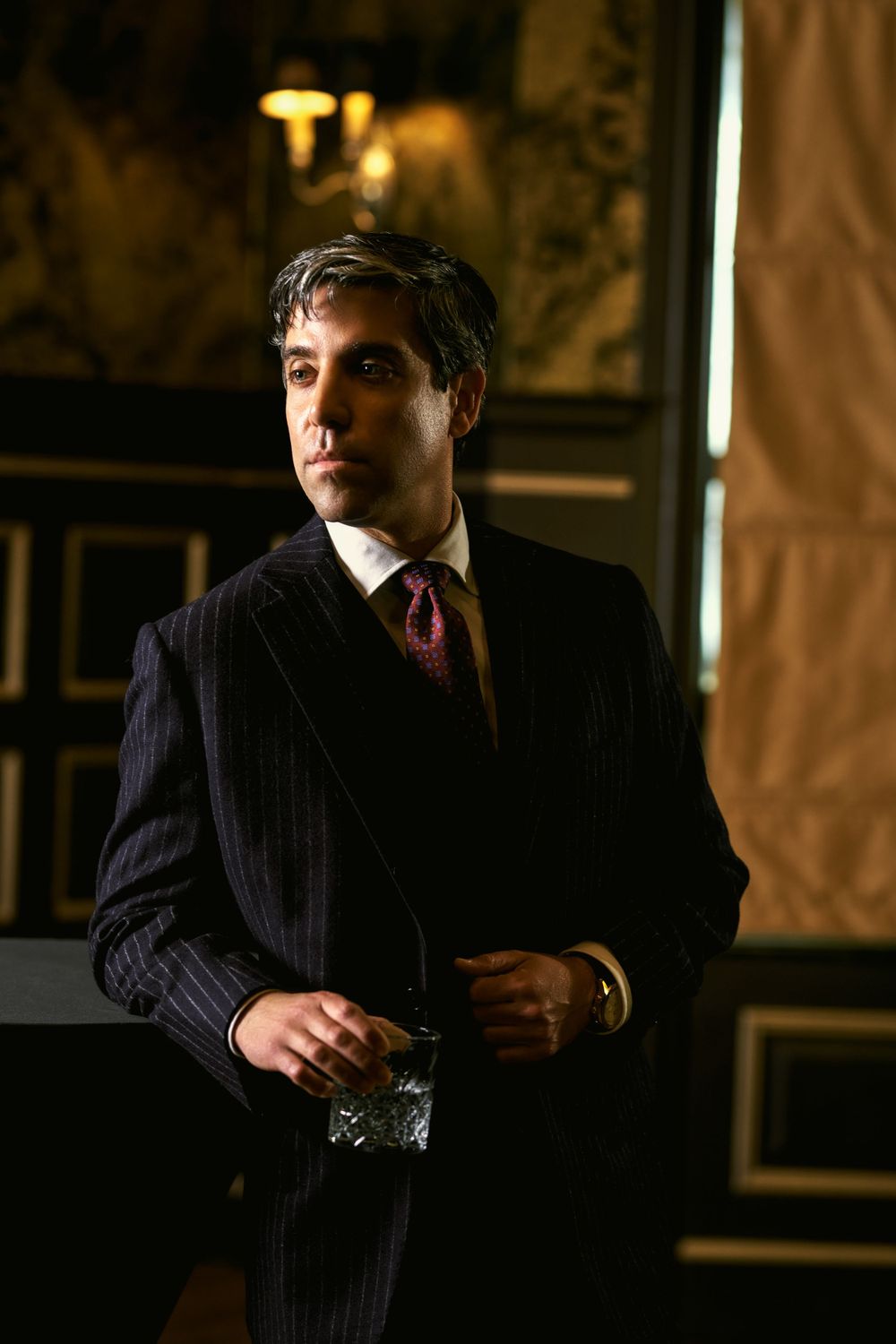 Moody portrait series in dark pinstripe suit jacket against dramatic lighting.