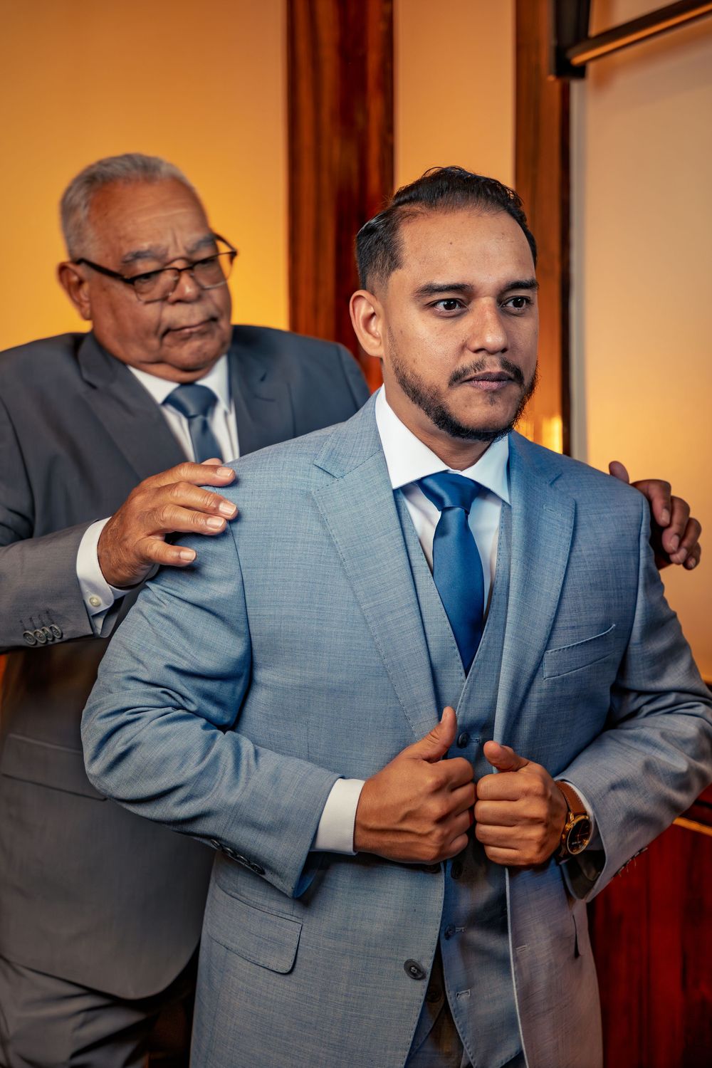 Wedding party members in gray suits adjusting their outfits and getting ready for the ceremony.