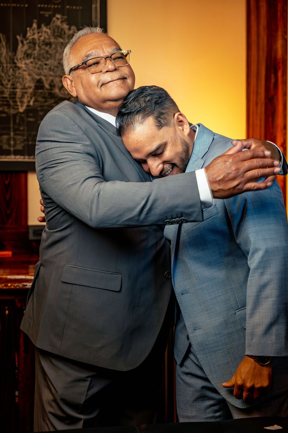 Groomsmen in suits share a lighthearted moment during wedding preparations.