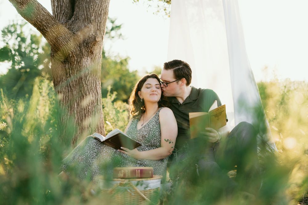 A romantic couple shares tender moments in a sunlit forest setting during a golden hour photo session.