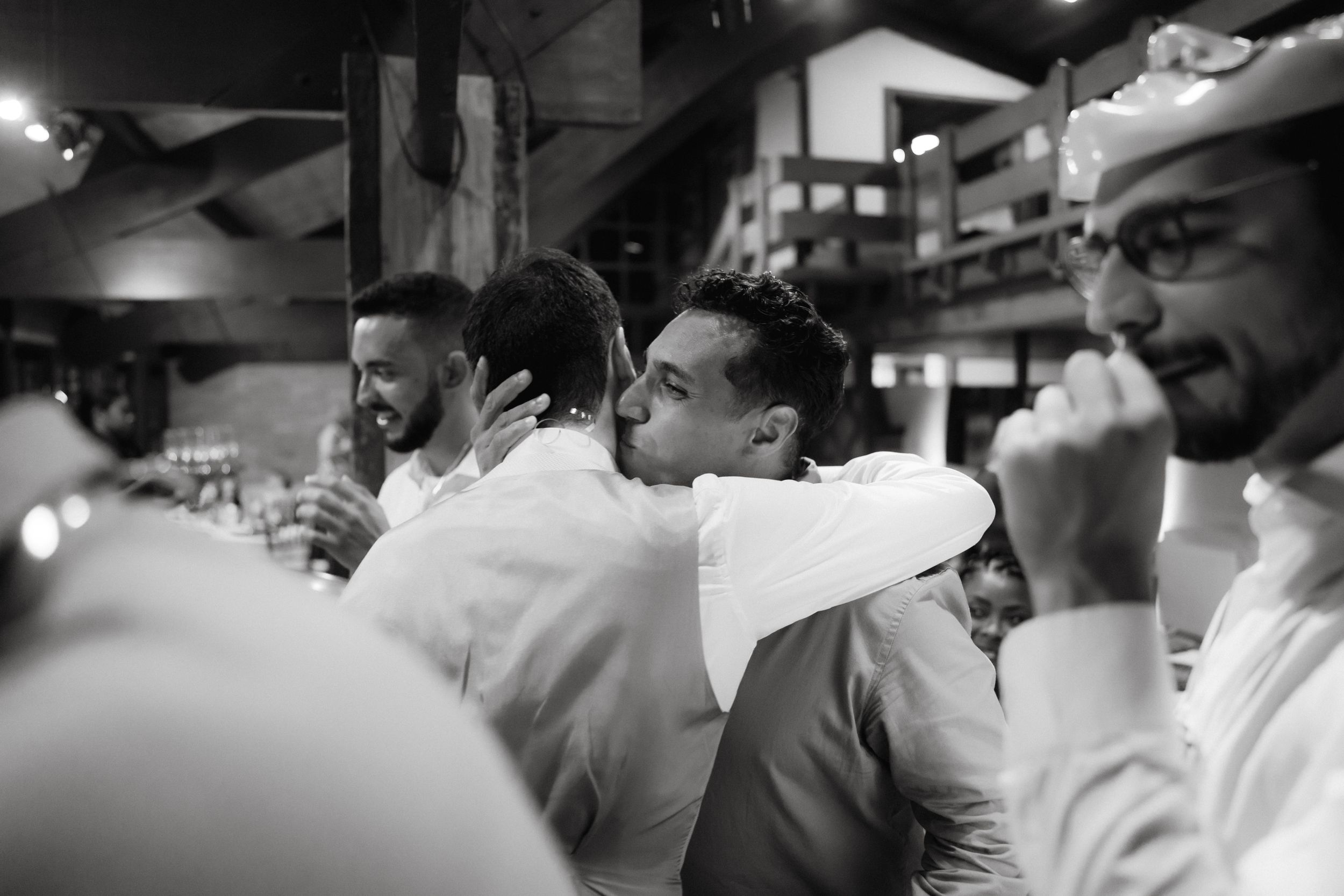 Black and white candid shot of guests enjoying themselves at a celebration.