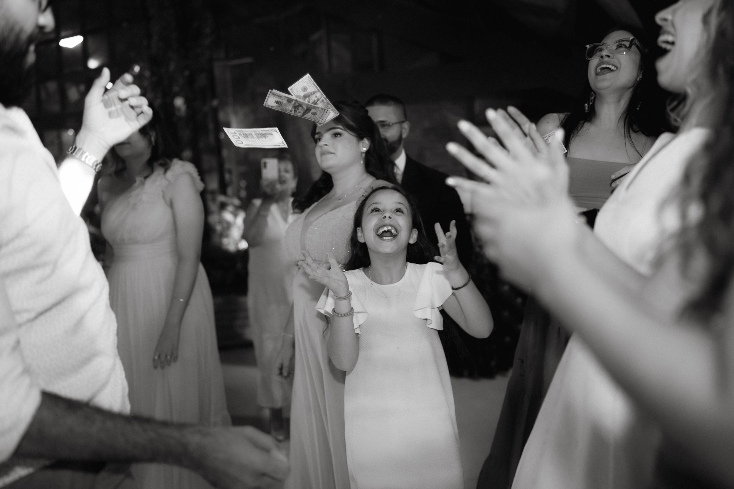 Black and white photo of guests celebrating joyfully at a party.