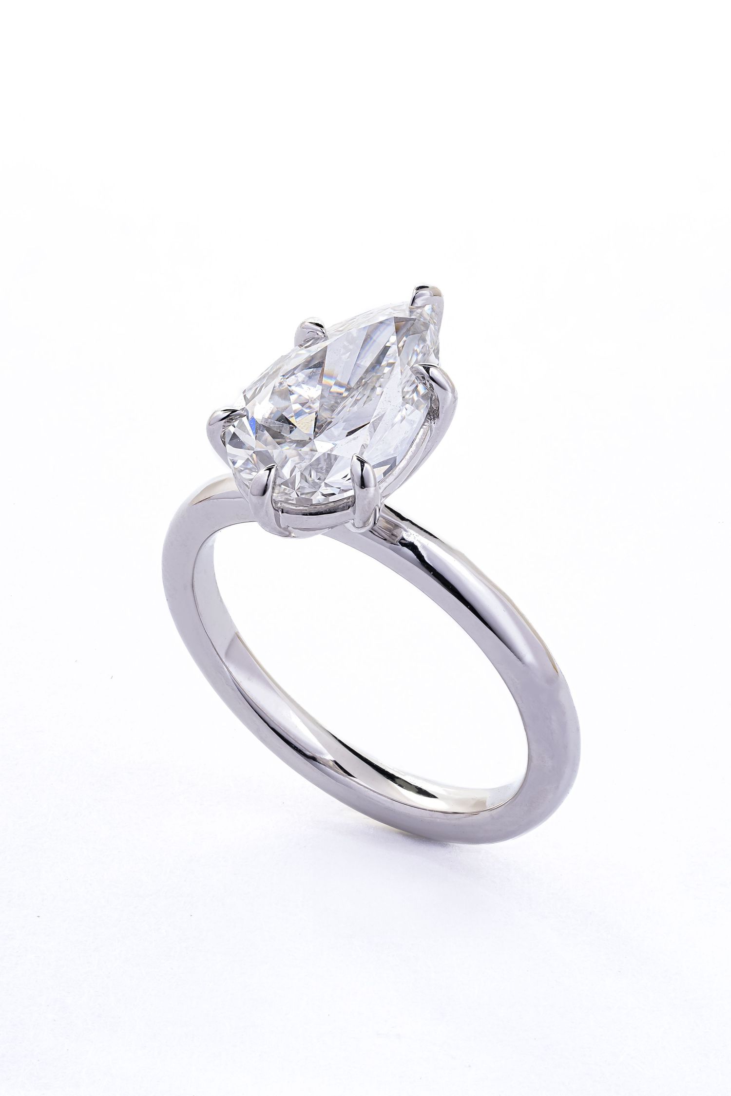 A solitaire engagement ring with a large pear-shaped diamond set in a sleek white gold or platinum band.