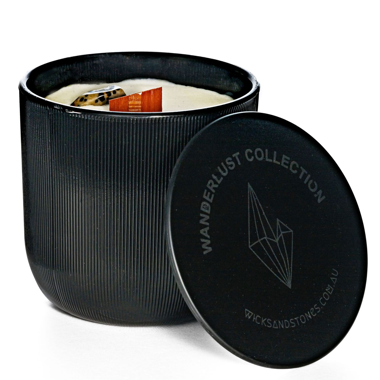 A black ribbed ceramic candle holder with wooden wick and geometric logo design on the lid.