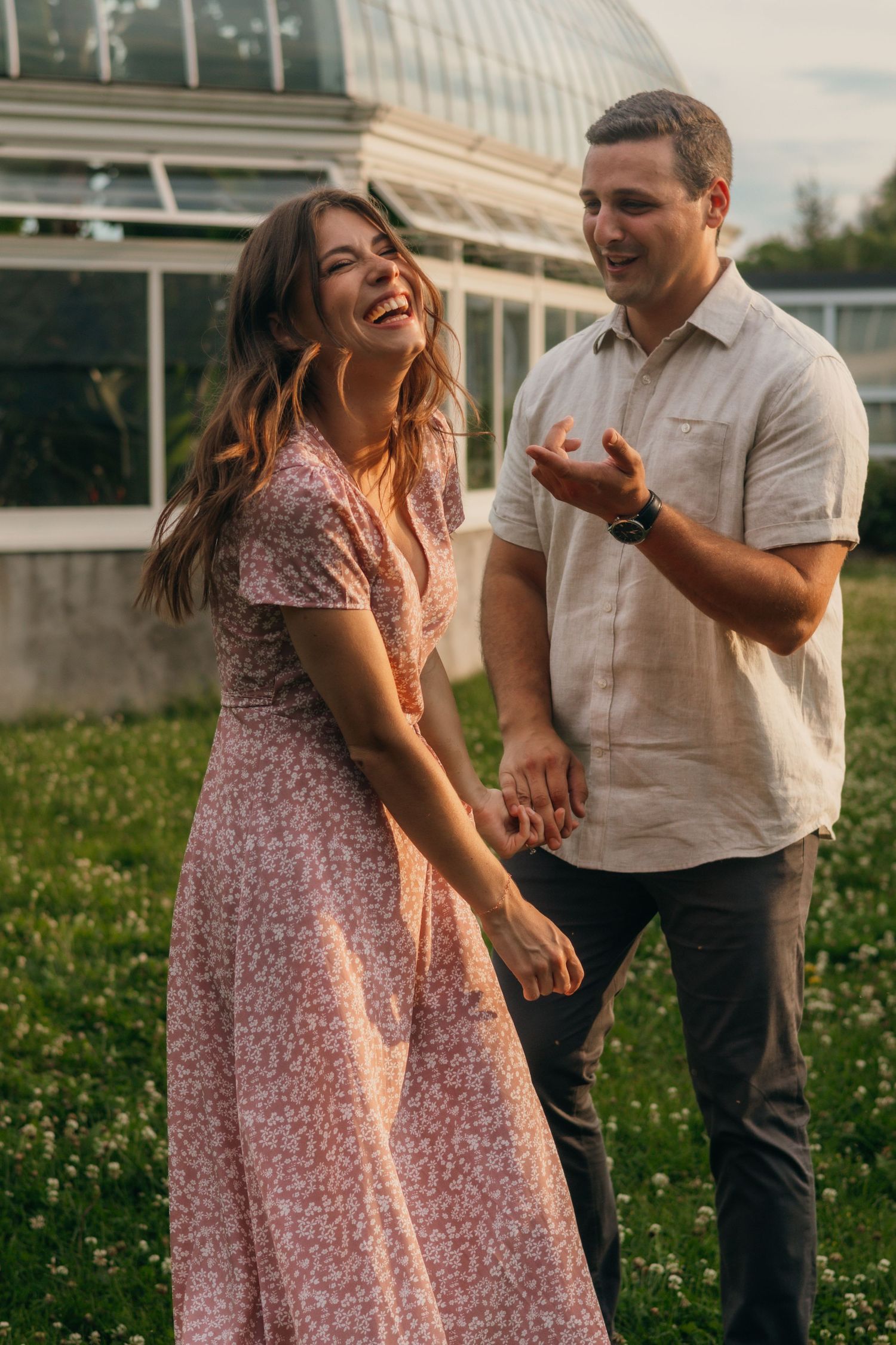 A man and woman laughing and holding hands.