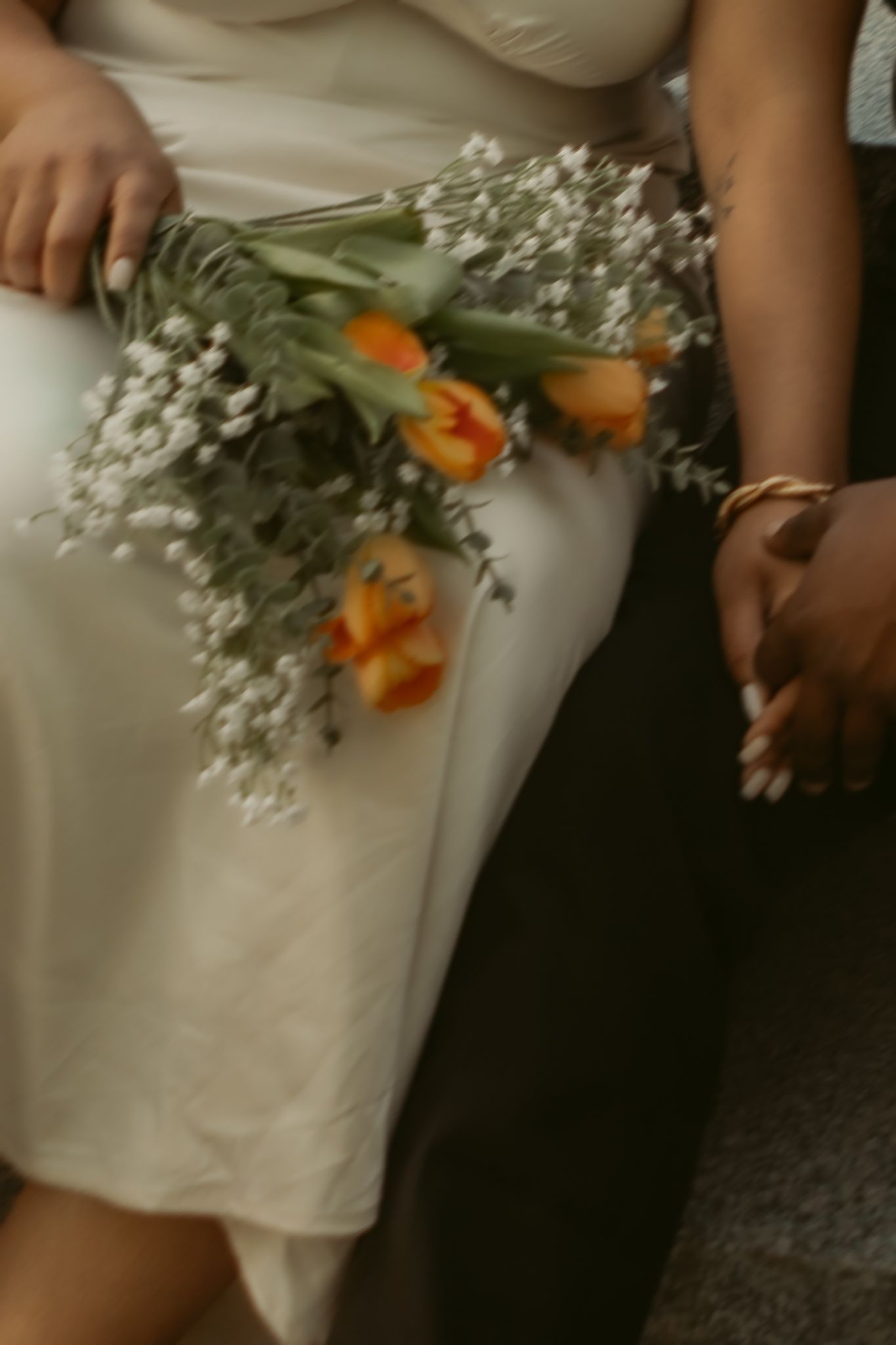 Close-up of hands of a man placing engagement ring on woman's finger during golden hour.