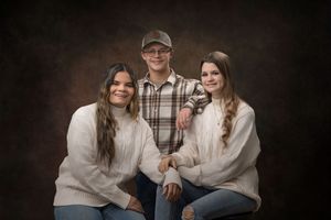 A collection of casual family portrait photos in neutral tones showing intimate moments against a dark background.