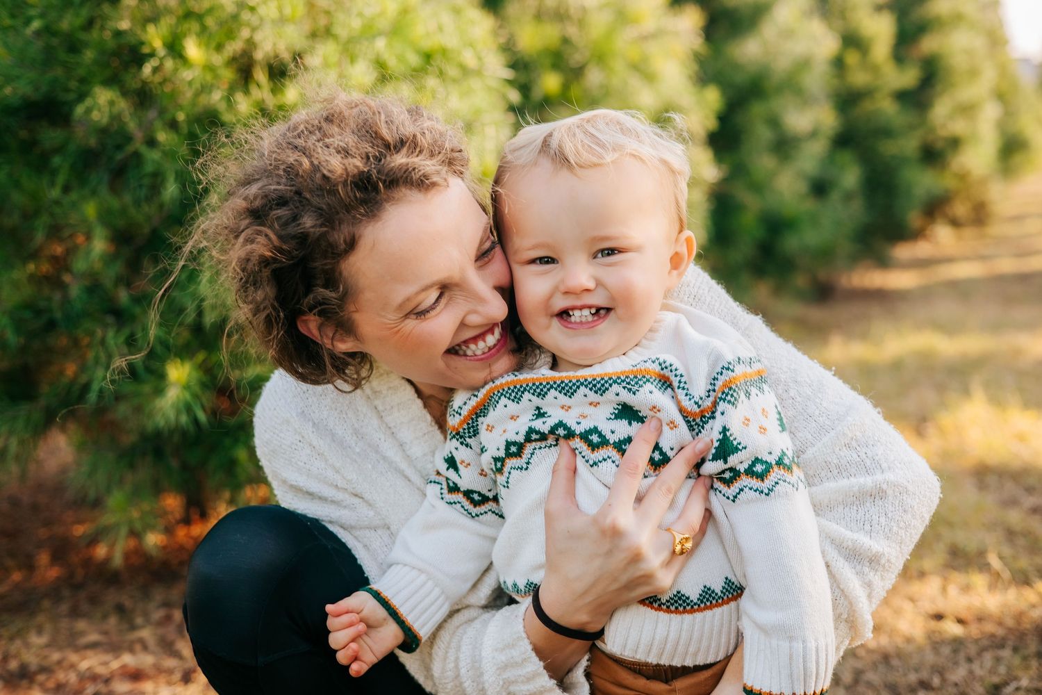 A joyful moment shared between parent and child wearing matching sweaters outdoors in autumn.