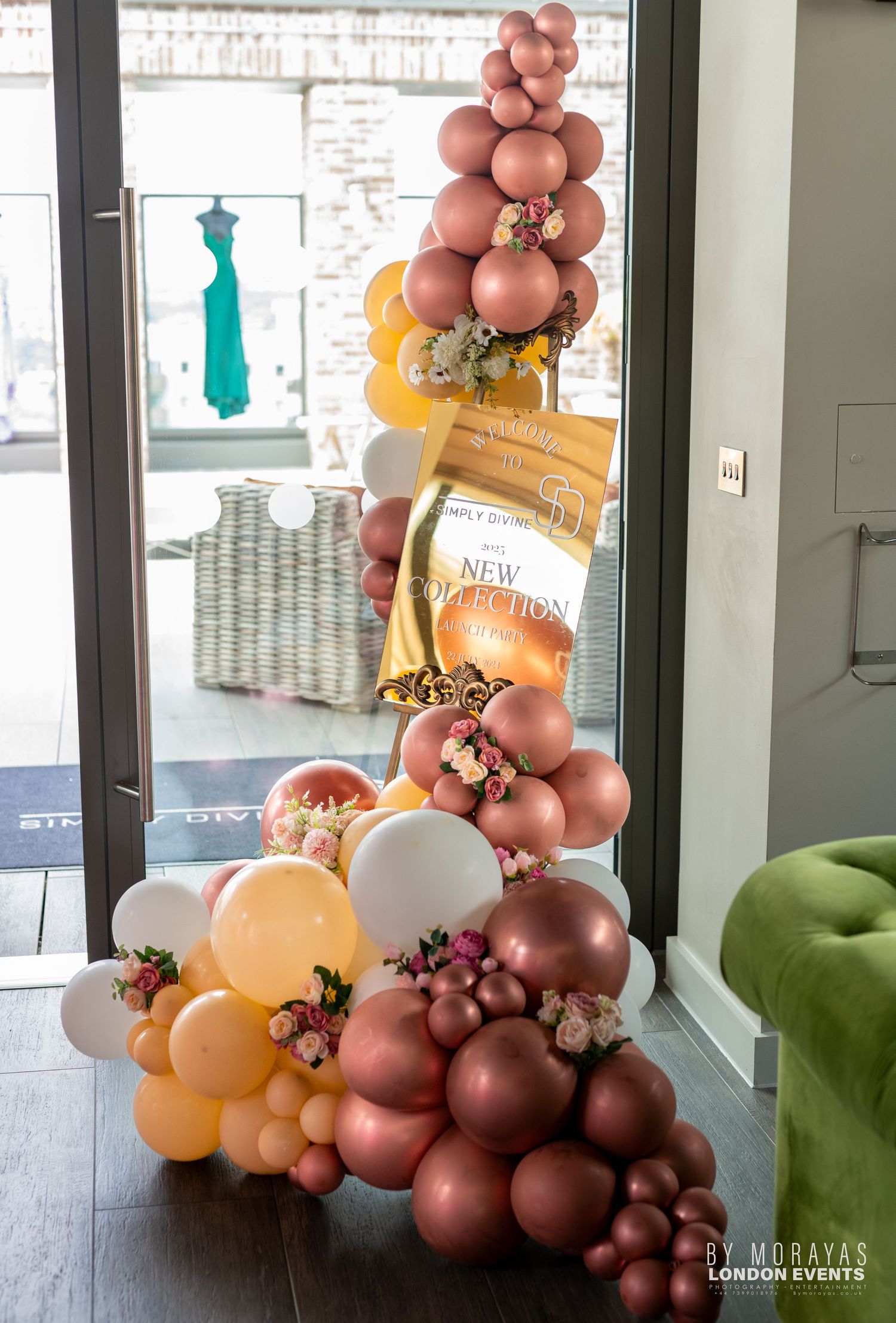 Elegant balloon arch display with rose gold and peach colored balloons in a modern interior.